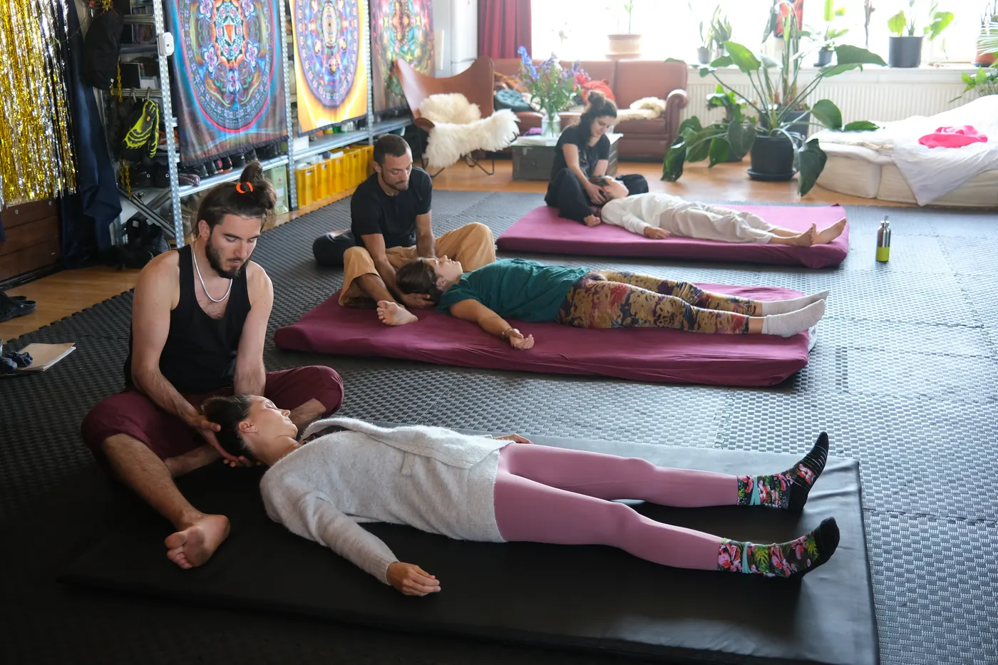 Massageworkshop met deelnemers op matten in de studio