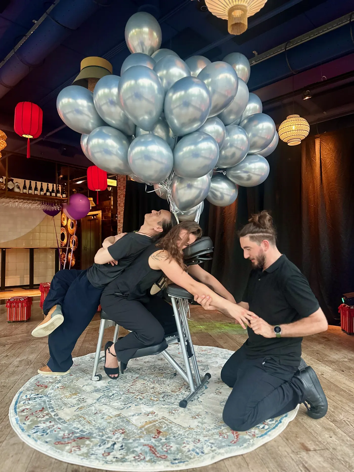 Michalis en twee collega's die stoelmassage geven op een bedrijfsevenement